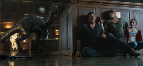 Jurassic World: Das gefallene Königreich mit Chris Pratt und Bryce Dallas Howard, die sich vor einem Dinosaurier verstecken